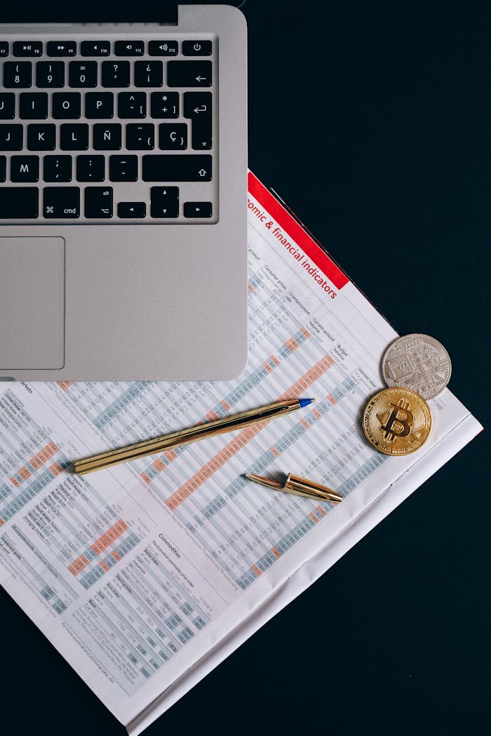 services-01 Top view of financial documents, laptop, and cryptocurrency coins on a desk.